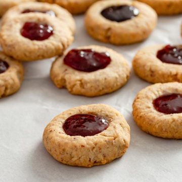 Six Thumbprint cookies filled in the center with jam.