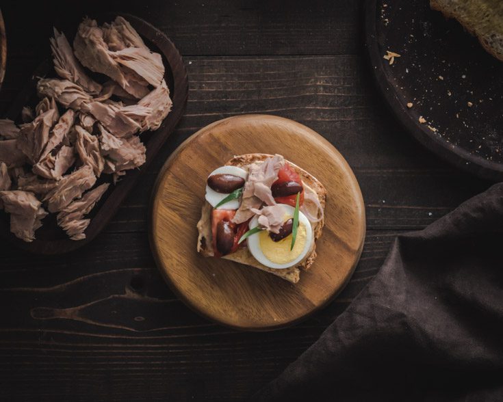 Overhead photo with a toast on a wooden plate.