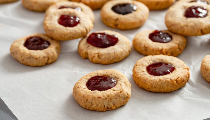 Several almond cookies filled with jam.