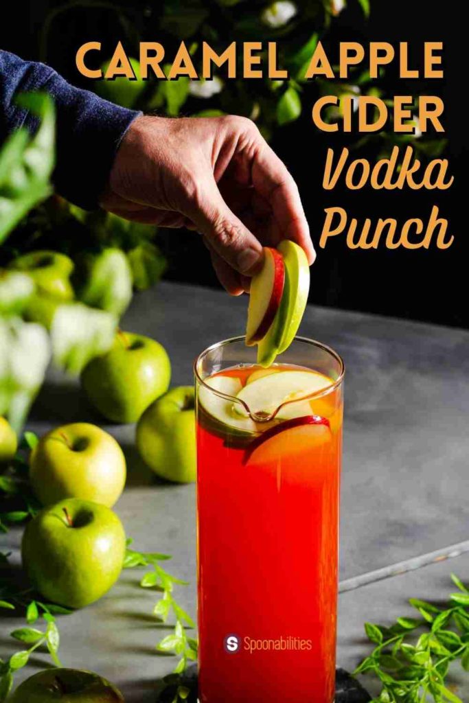 Inserting slices of red and green apples as garnish for Caramel Apple Cider Vodka Punch