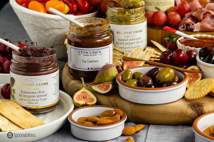 Unique dips and spreads for a charcuterie board: olive spread, fig chutney, and red pepper spread.