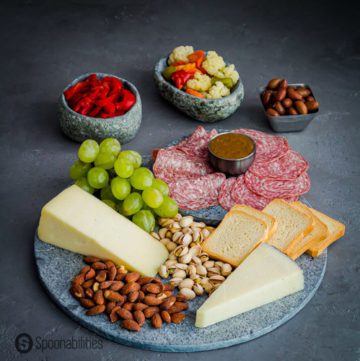 salami, cheese, nuts and grapes on a marble charcuterie board