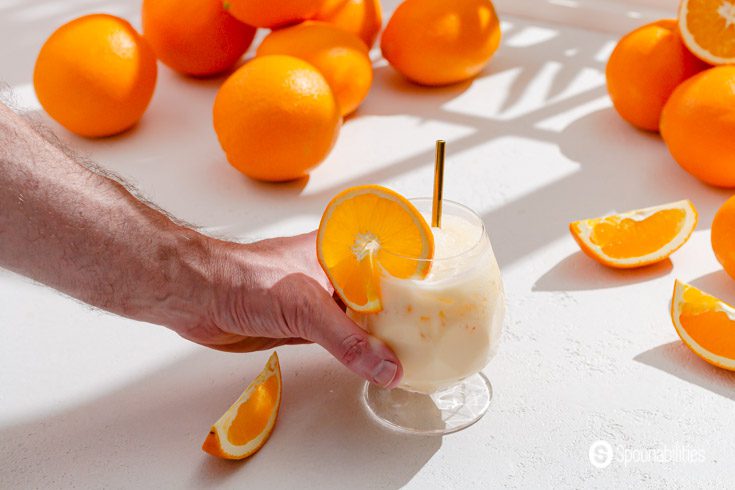 A hand holding a glass with Morir Sonando aka morir soñando. This is a popular Dominican drink during the summer.