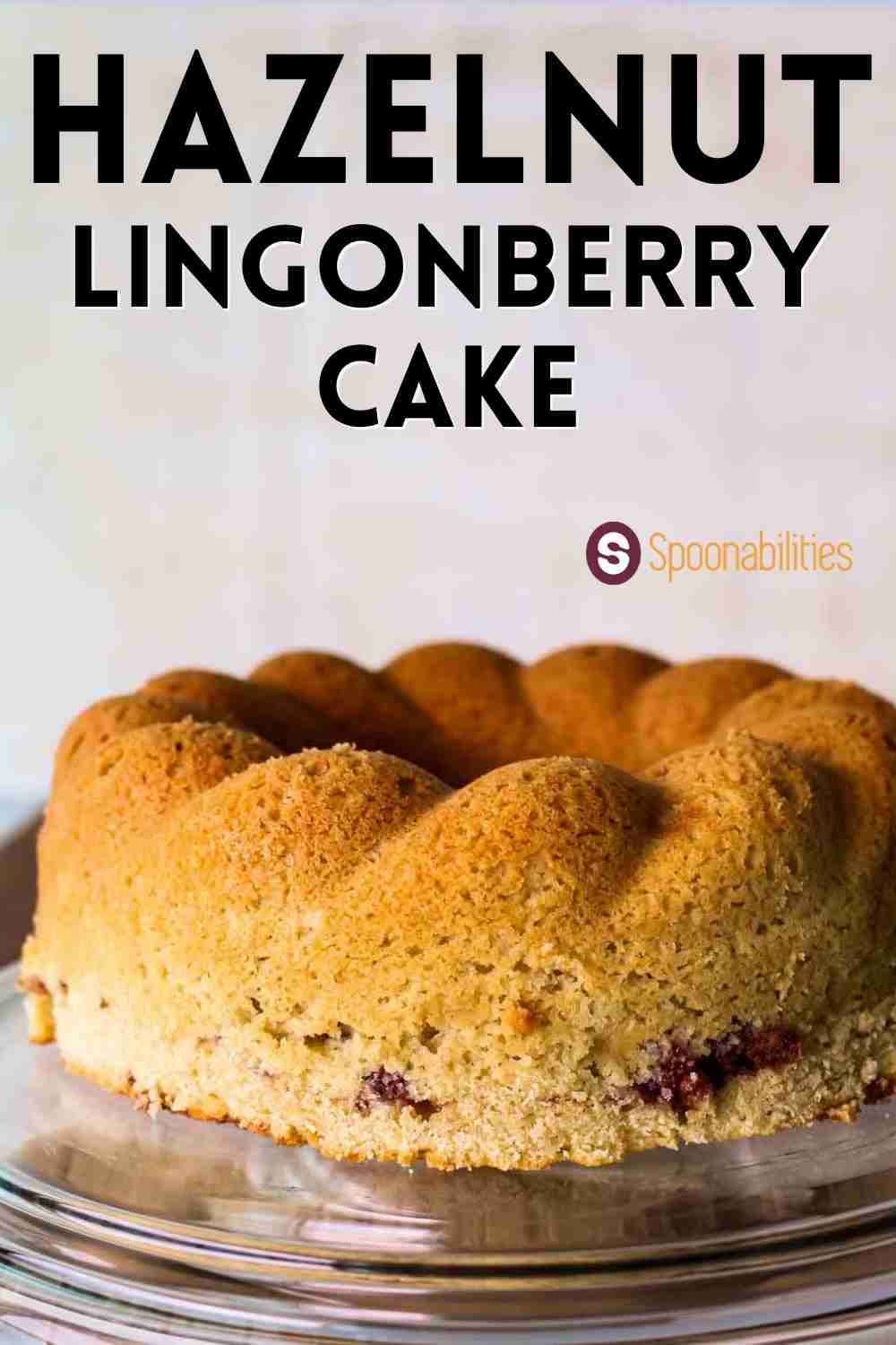 uncut Hazelnut Lingonberry Cake on a glass cake stand