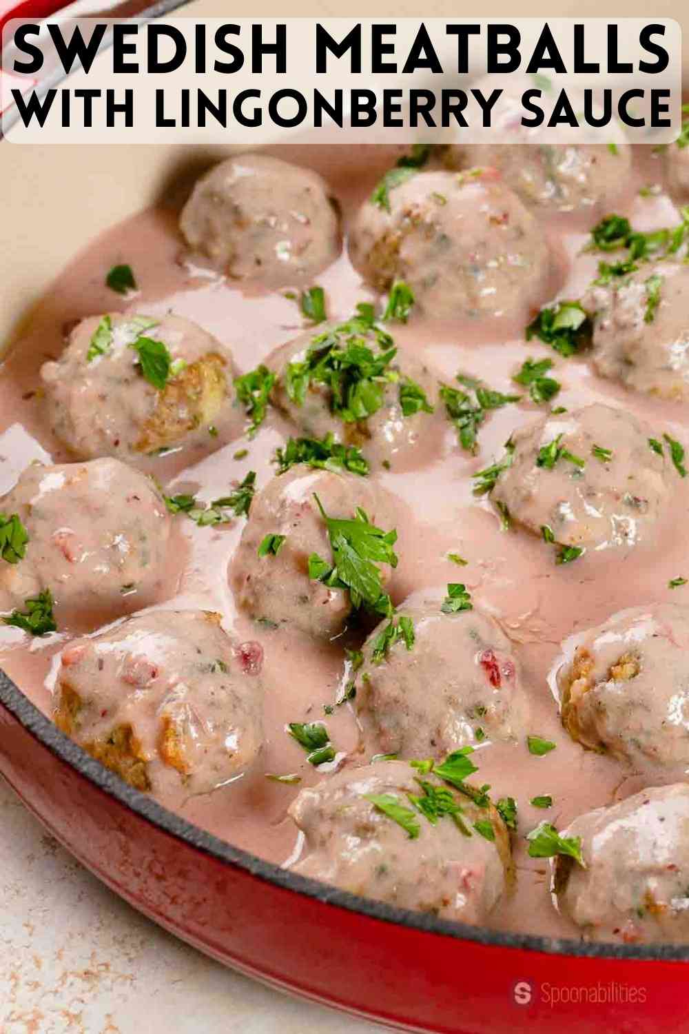 a close up photo of Swedish Meatballs with Lingonberry Sauce in a red pan. Recipe available at Spoonabilities.com