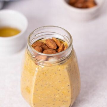 a close up photo of pumpkin overnight oats with almonds on top