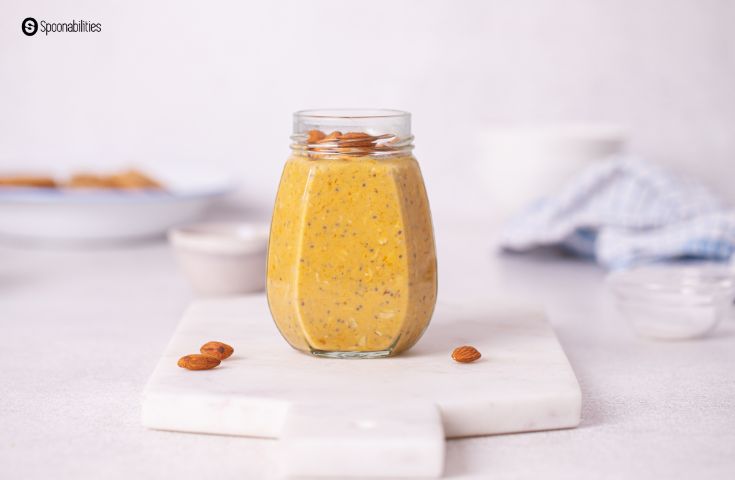 Pumpkin Overnight Oats ion a clear glass jar with whole almonds on top and 3 almonds on the side.