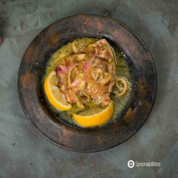 A photo of Baked Chicken Thighs with Honey Mustard Sauce, with lemons on a marble plate.