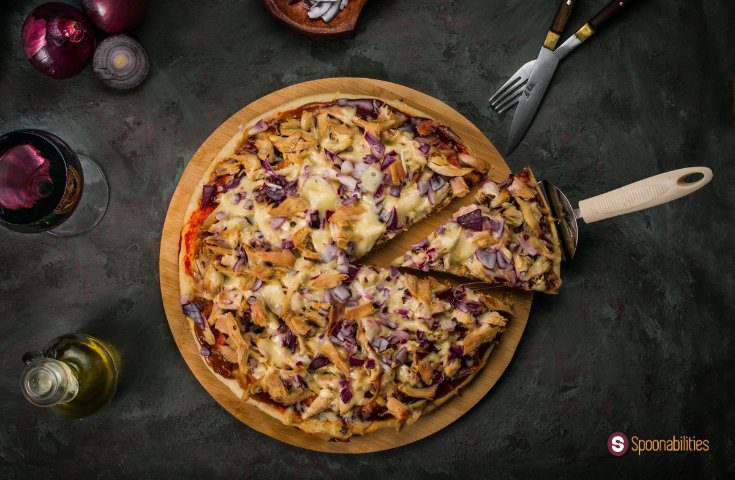 slice of chicken pizza being served from the pie