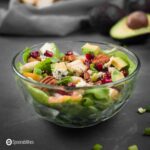 a close up photo of Honey mustard vinaigrette on butter lettuce pear salad in a clear bowl