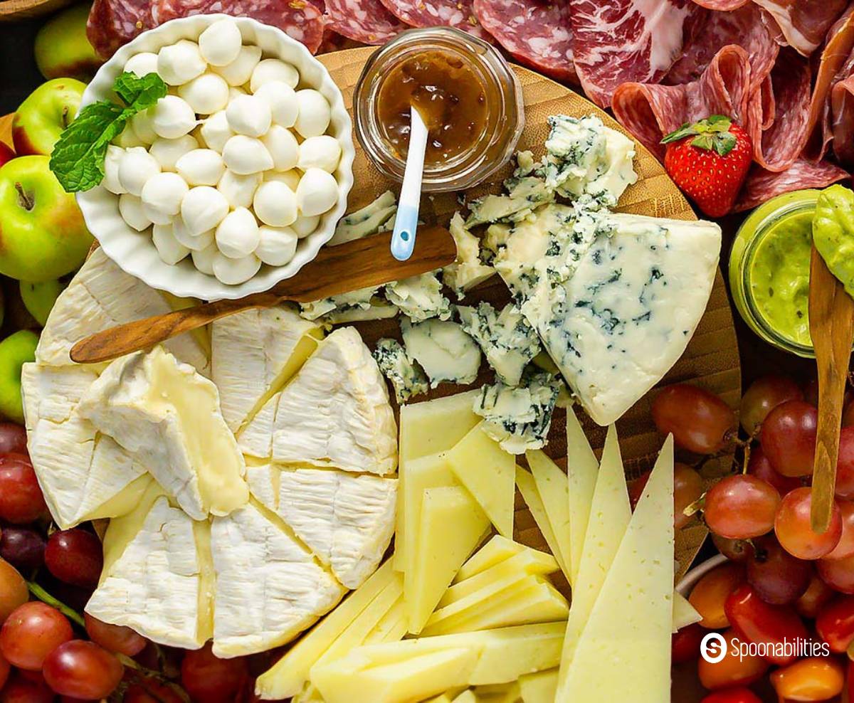 Cheese board with hard cheese, soft cheese, mozzarella balls and spreads in jars