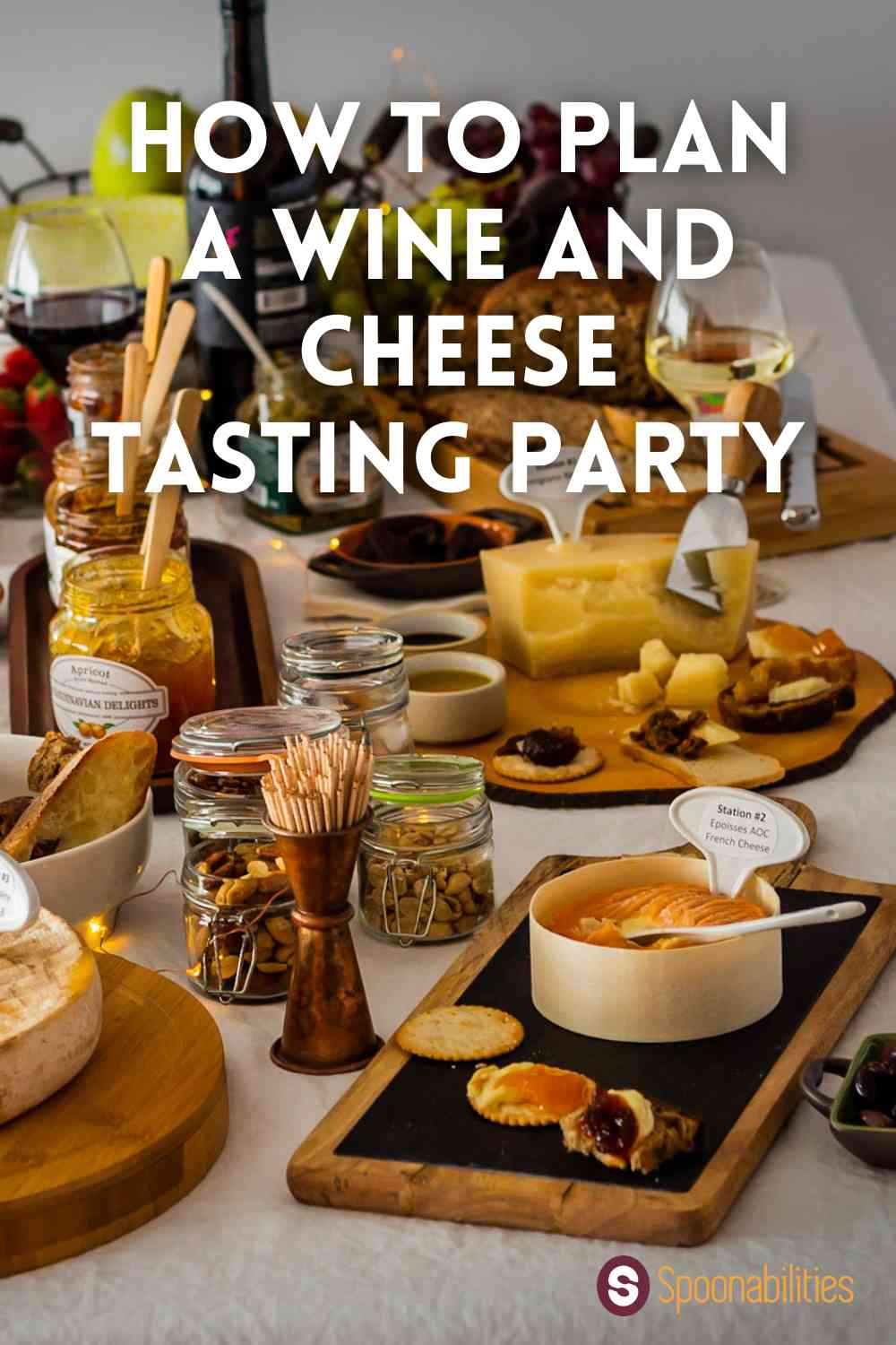 Wine and cheese tasting party table with cheeses, wine in glasses, assorted nuts and condiments