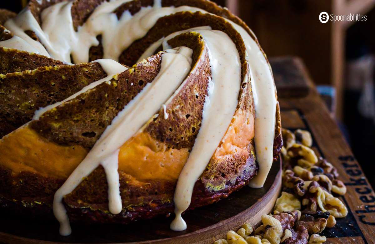 Close up of pumpkin carrot bundt cake with cream cheese flowing on the sides