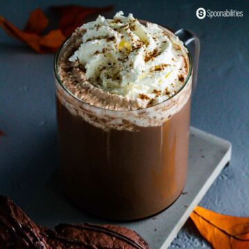 Overhead shot of pumpkin spice mocha with whipped cream and caramel sauce in a clear glass