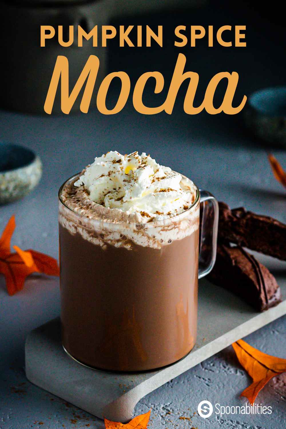 Pumpkin Spice Mocha with whipped cream on top and a couple of chocolate pastries at the back