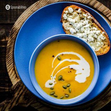 A bowl of roasted butternut squash soup with a slice of Feta Honey Toast on the side.