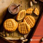 Classic peanut butter cookies in a tray with chocolate milk with a straw