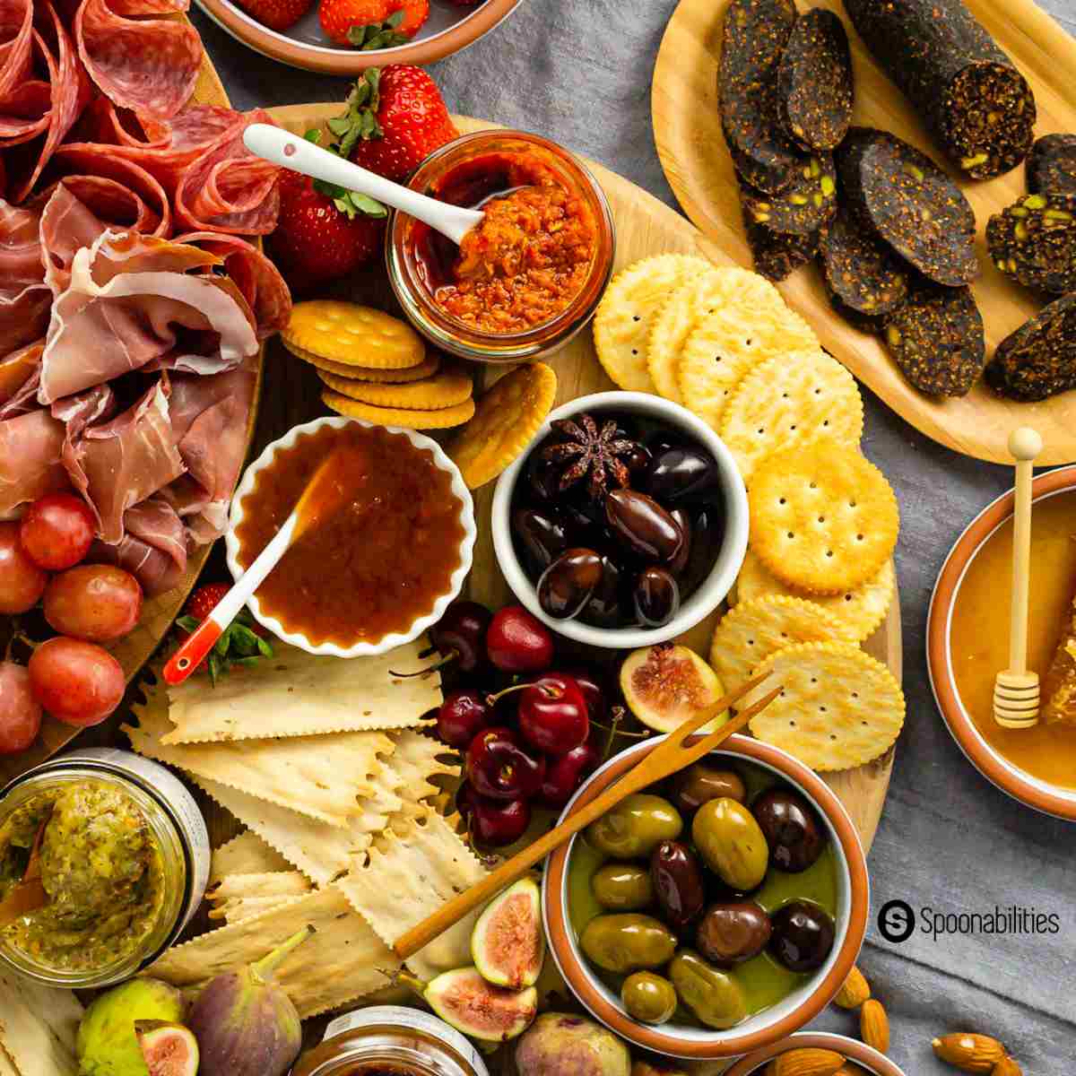 Charcuterie board with meats and spreads, with crackers and fresh and dried fruits