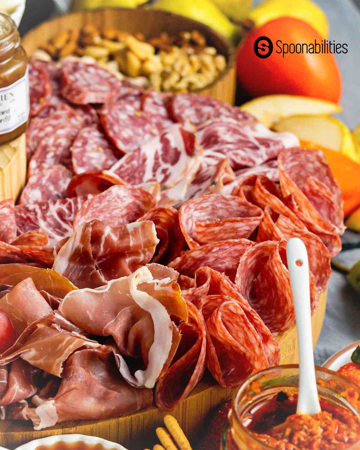 charcuterie board meats with nuts and jars of spread