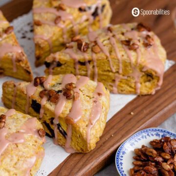 Pumpkin scones with glaze on a wooden chopping board
