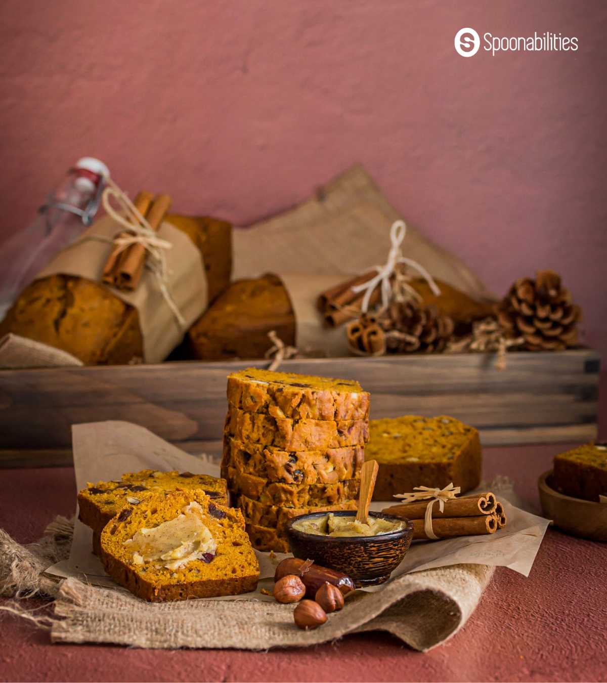 pumpkin bread slices stacked together with a small bowl of butter