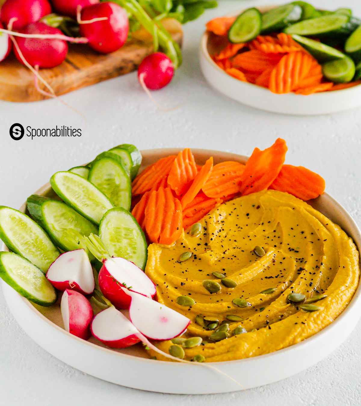 vegetable appetizer platter with sliced fresh veggies in the background