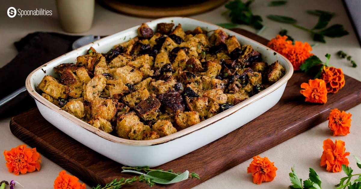 Mushroom stuffing in a white baking dish with orange flowers around it