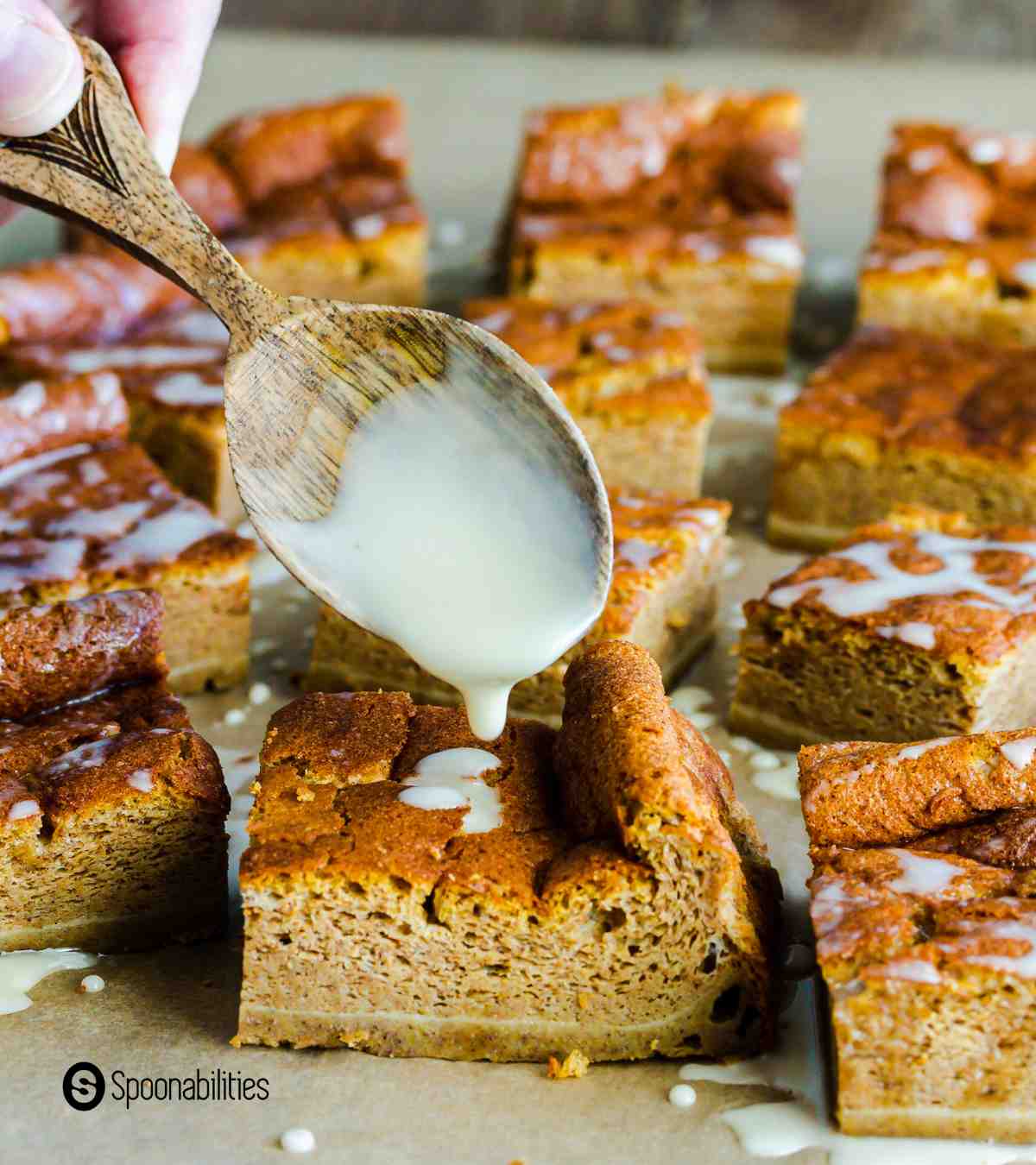 Drizzling white syrup over pumpkin magic cake