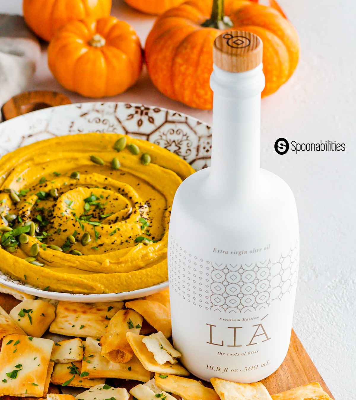 extra virgin olive oil from our food suppliers in a white bottle in front of pumpkin hummus