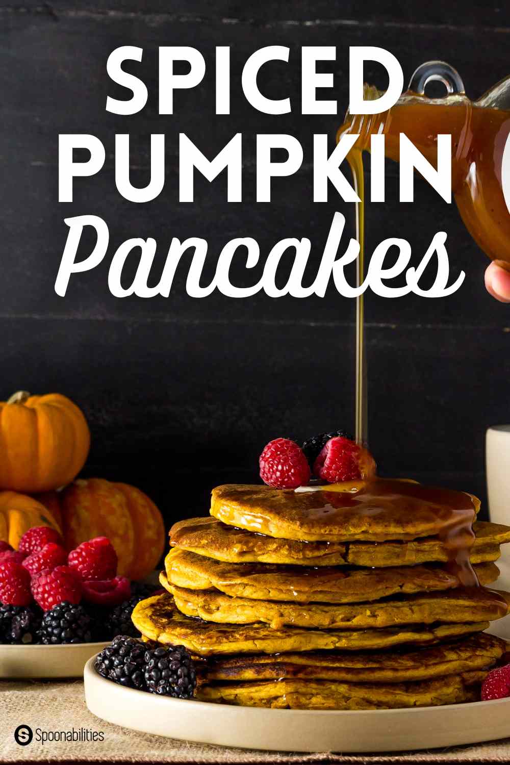 Maple syrup poured on top a stack of spiced pumpkin pancakes