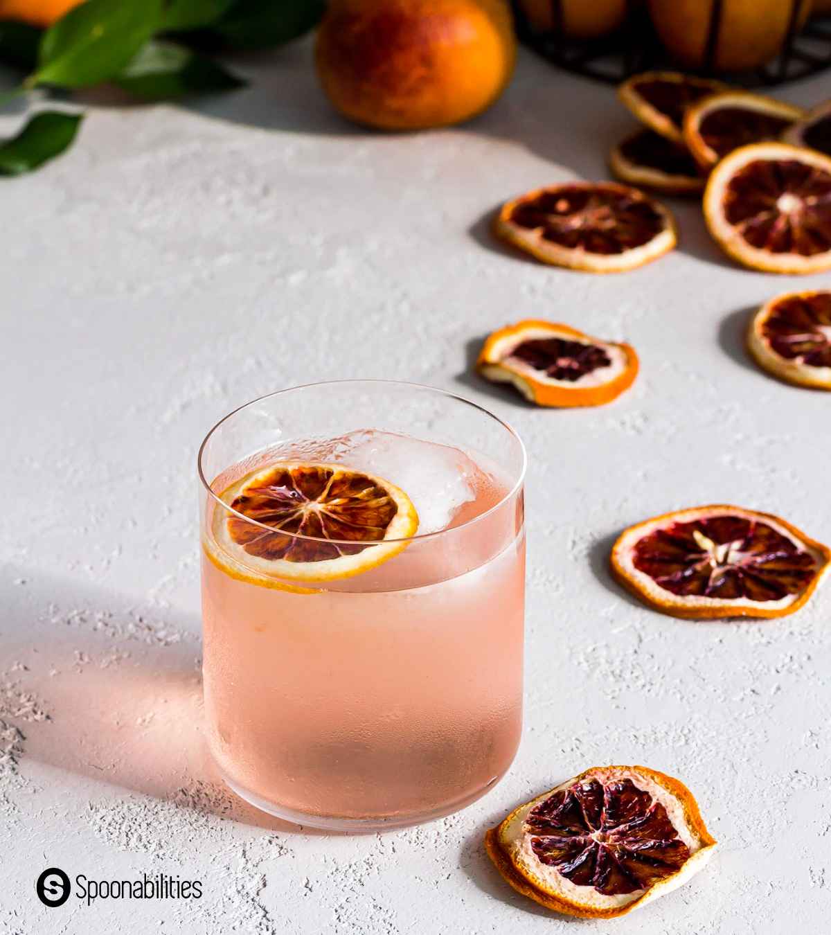 A slice of dried blood orange as garnish on top of blood orange vodka cocktail