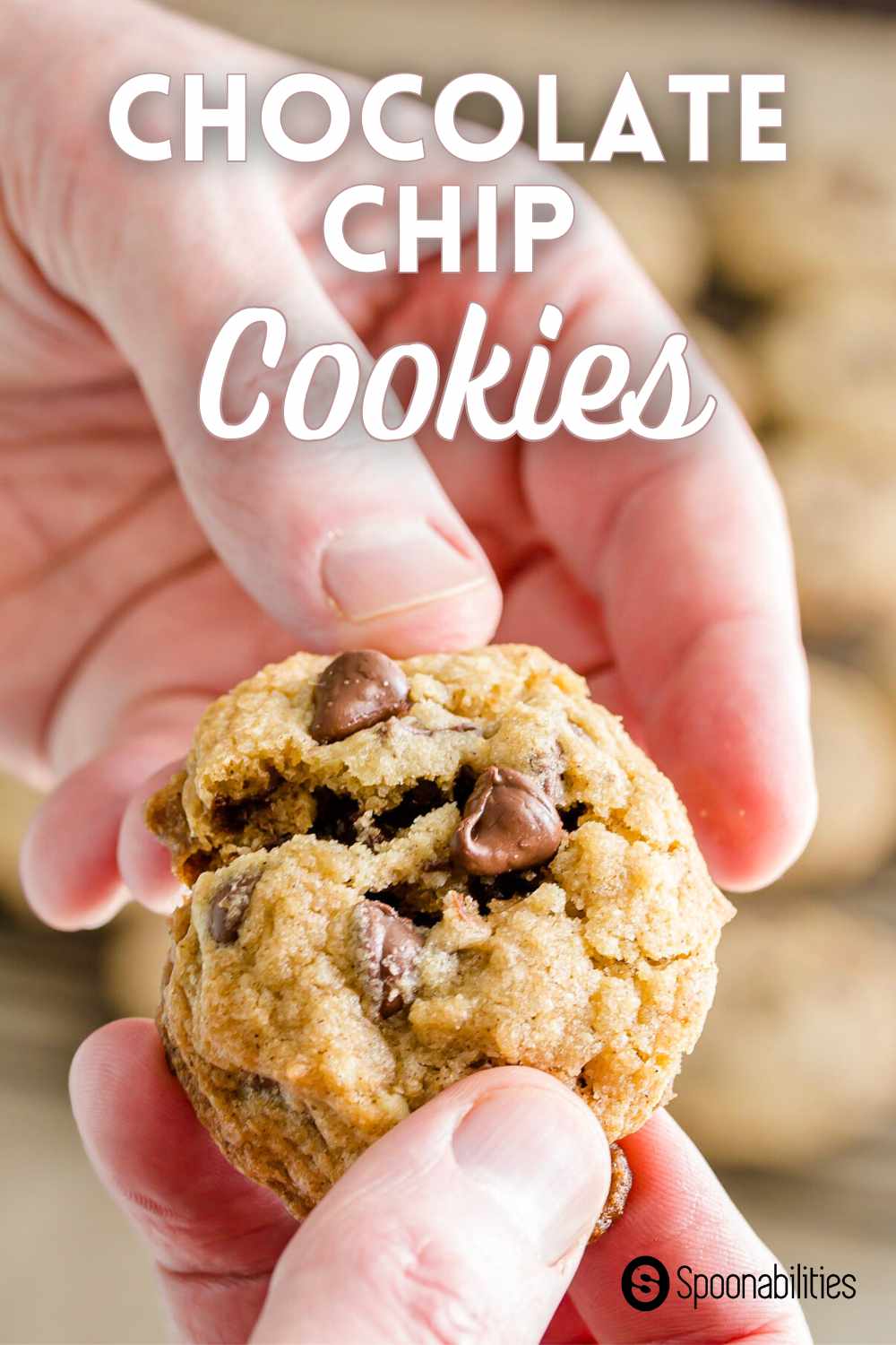 Hands breaking off a chocolate chip cookie