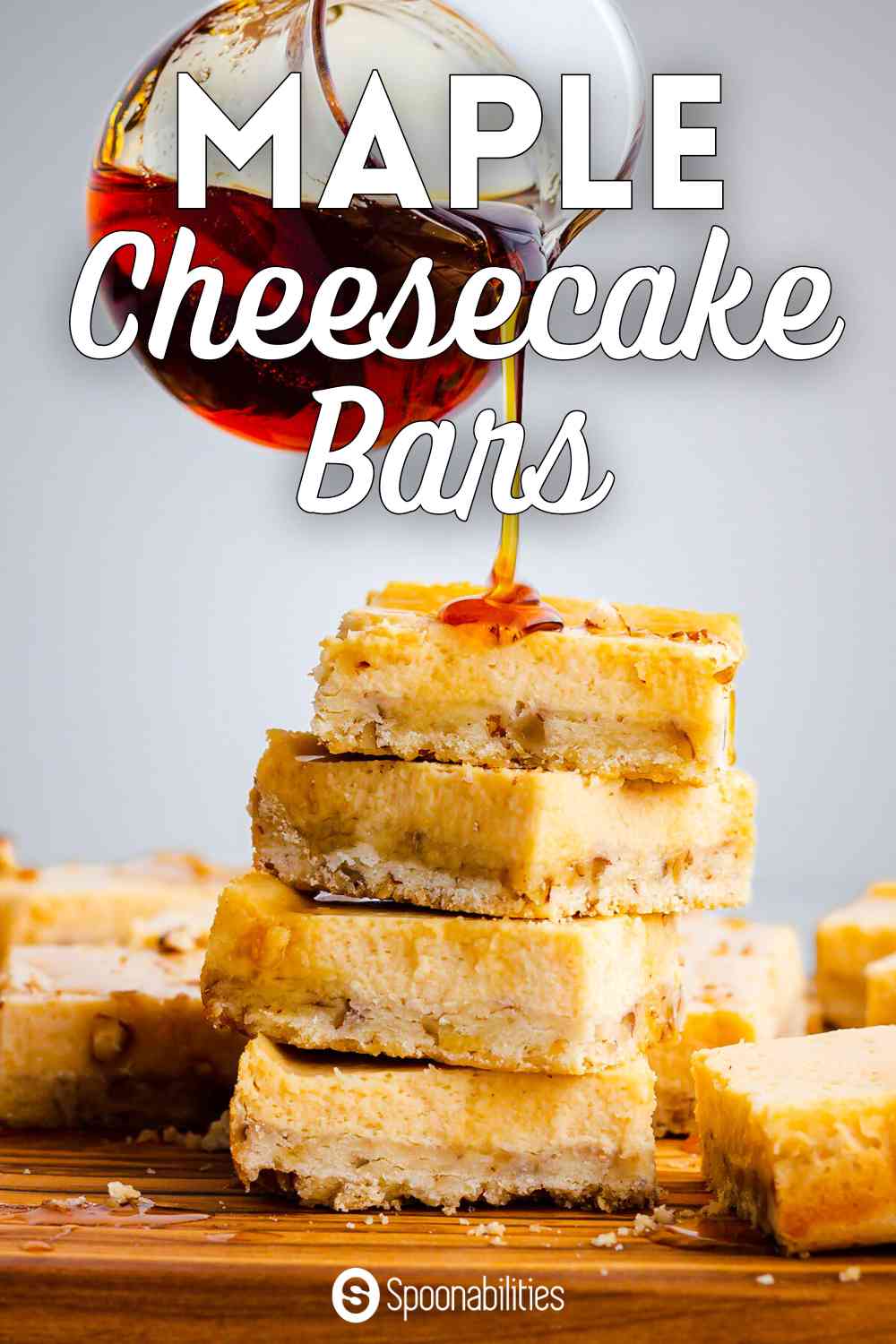 Pouring maple syrup over cheesecake bars stacked together