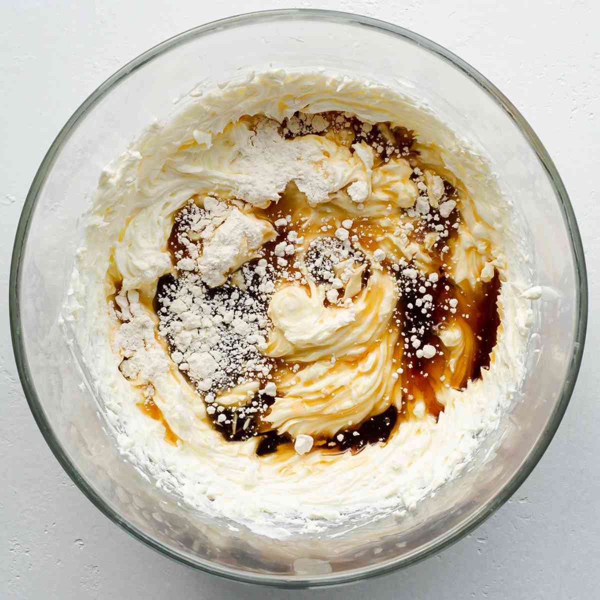glass mixing bowl with cream cheese, flour and maple syrup