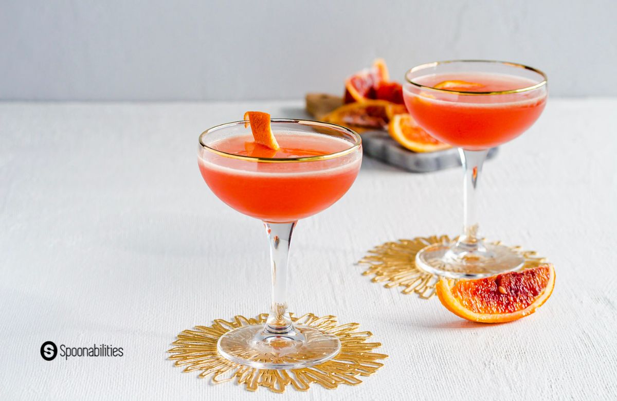 Blood orange cocktails in glasses with orange zest garnish